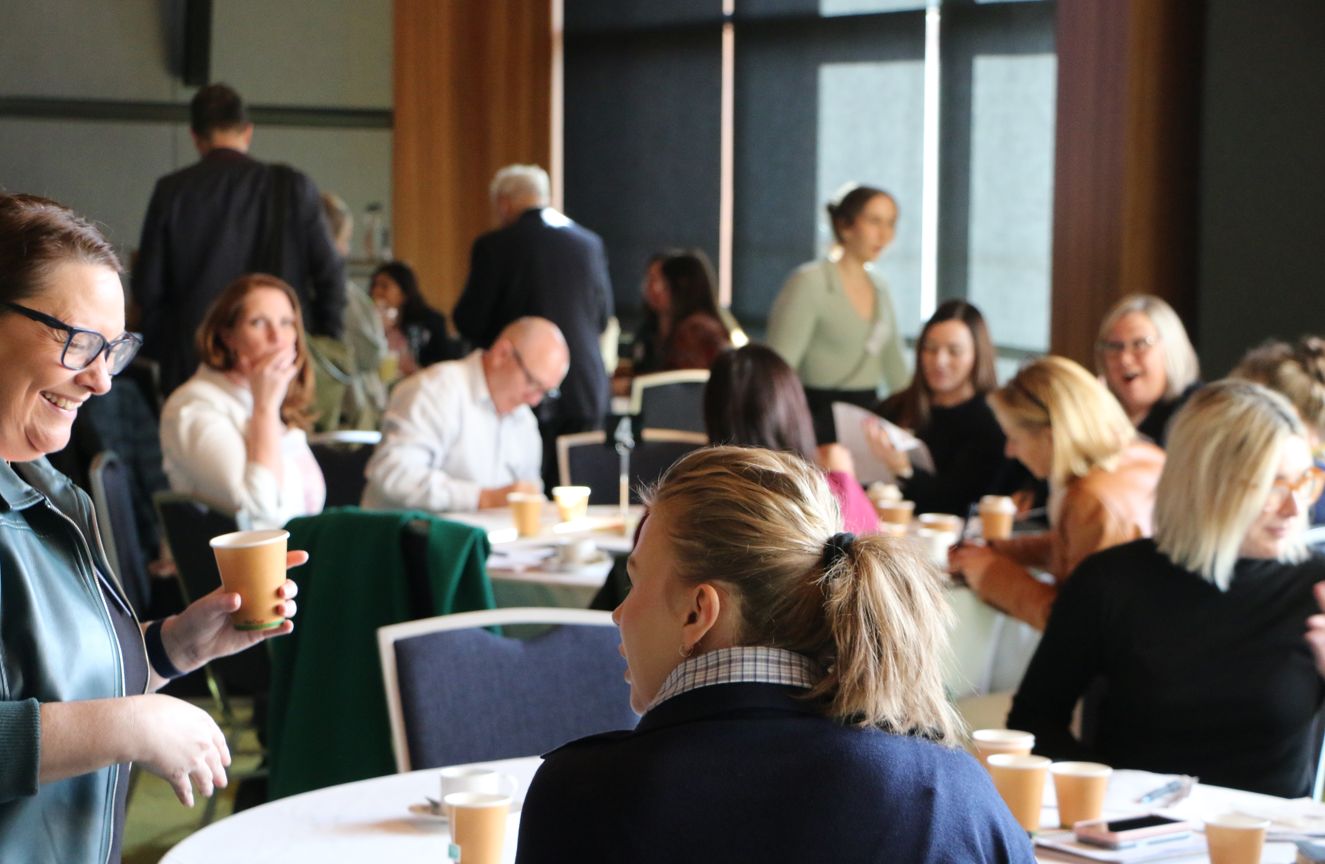 People sitting in a room at circle tables